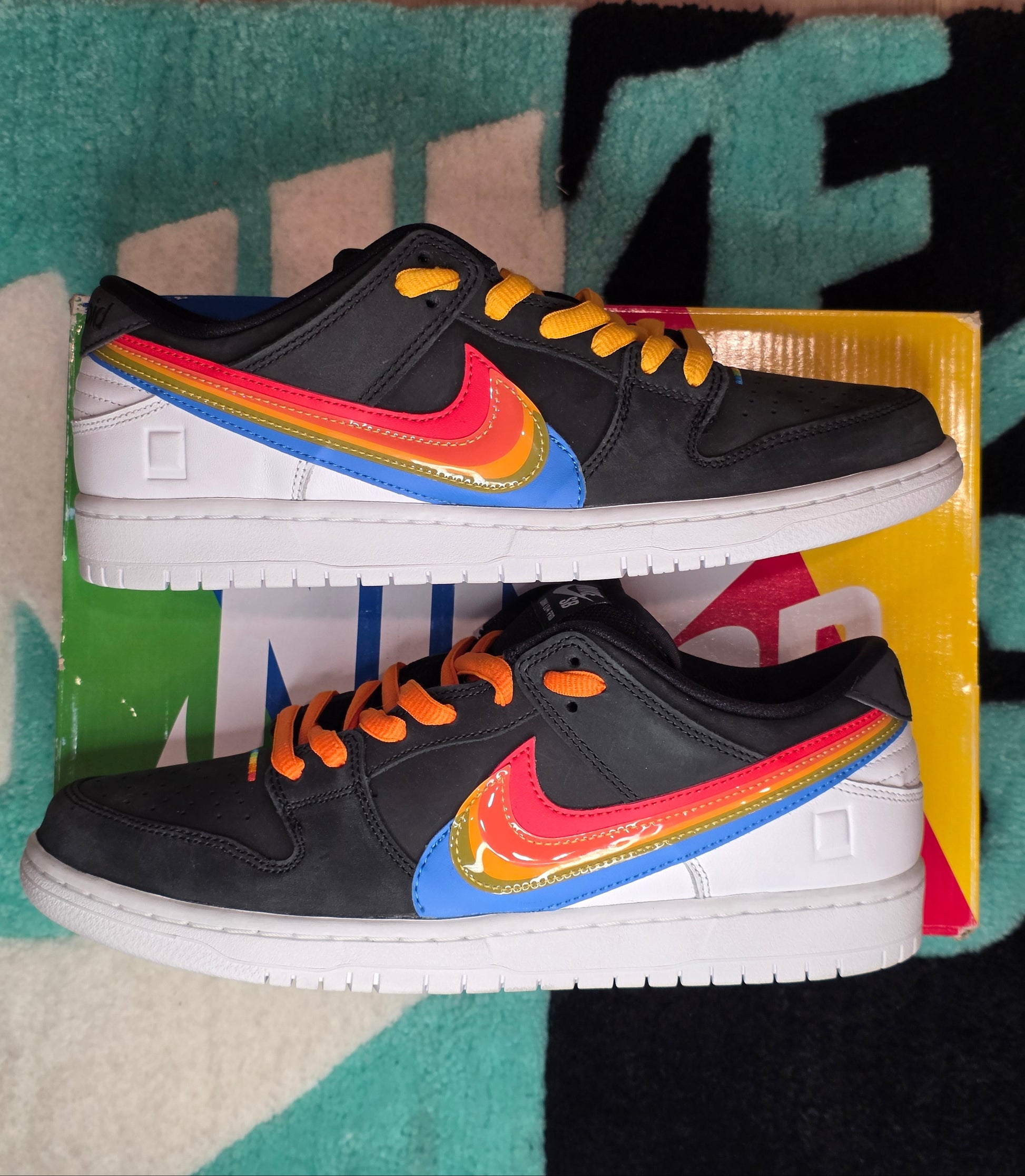 Black sneakers with colorful accents on a patterned rug